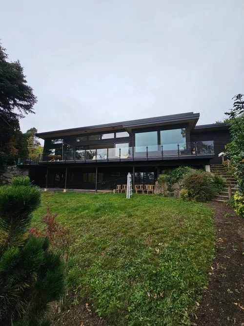 Modern custom home with expansive windows and landscaped yard