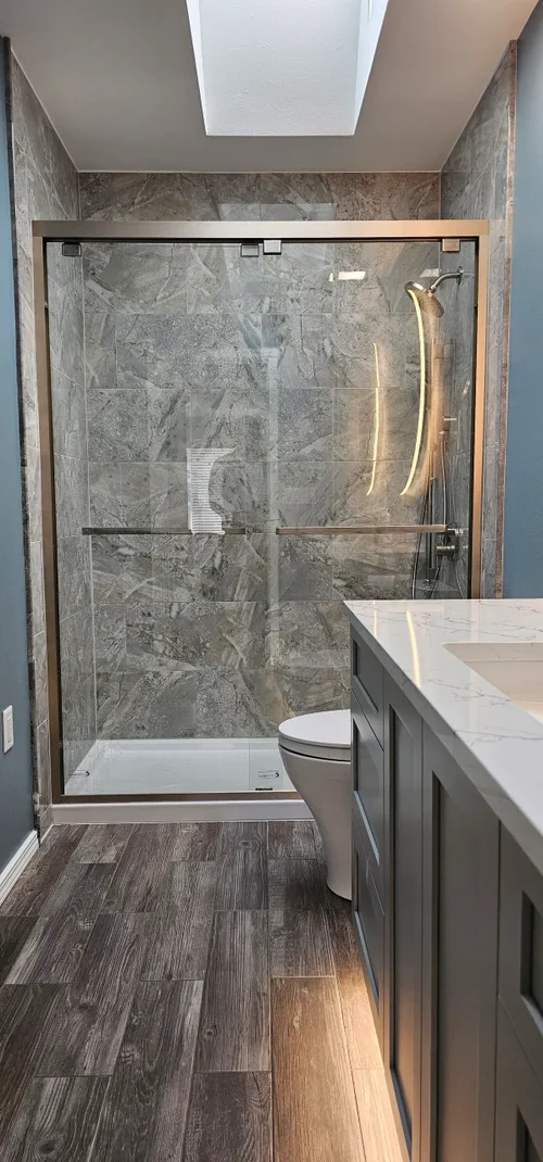 Modern bathroom featuring a tiled walk-in shower and floating vanity